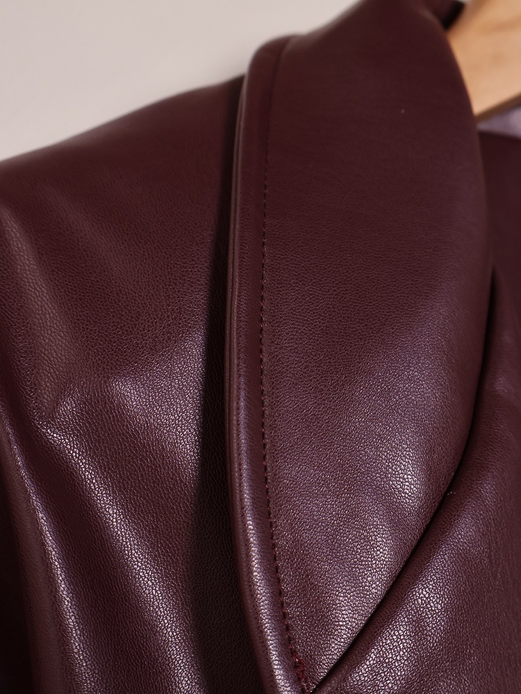 Giacca peplum da donna in similpelle color rosso vino con cintura.
