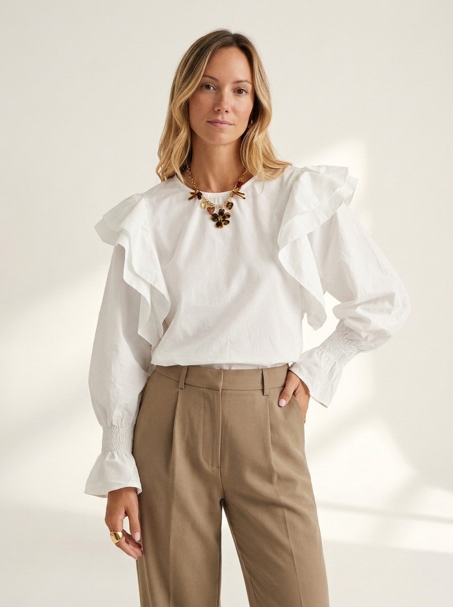 Chemisier élégant à manches bouffantes et volants, orné d'un lien au dos.