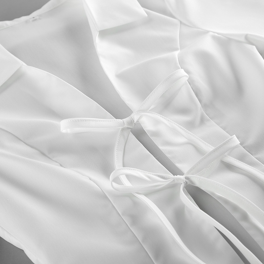 Camicetta da donna a maniche lunghe con colletto e laccetti sul davanti, colore bianco.