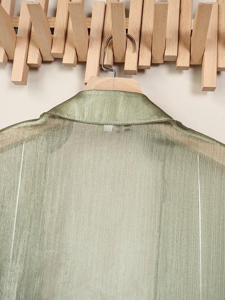 Blusa corta avvolgente verde scintillante e trasparente con nodo sul davanti