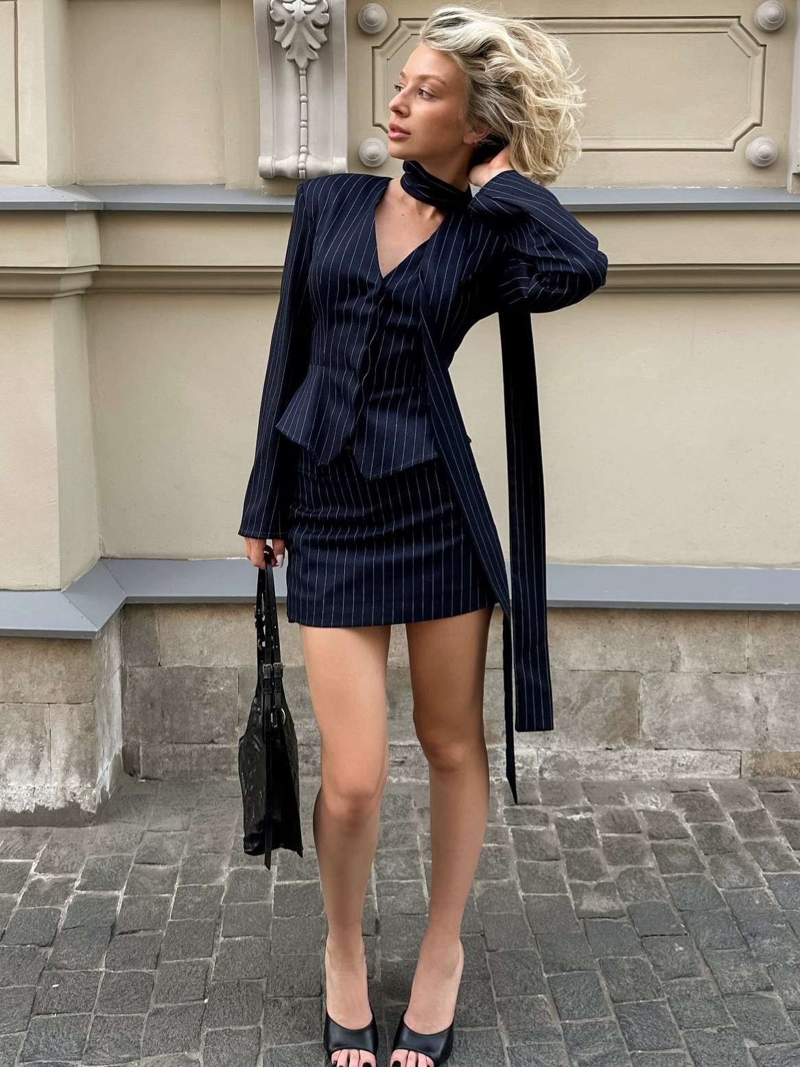 Completo composto da blazer gessato, minigonna e sciarpa.