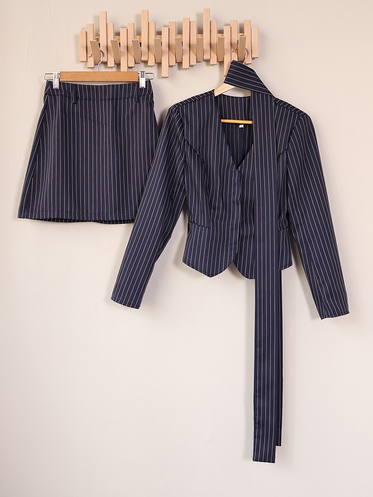 Completo composto da blazer gessato, minigonna e sciarpa.