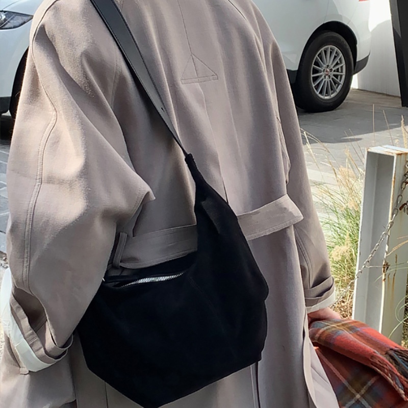 Bolso de hombro tipo hobo de ante con cierre de cremallera.