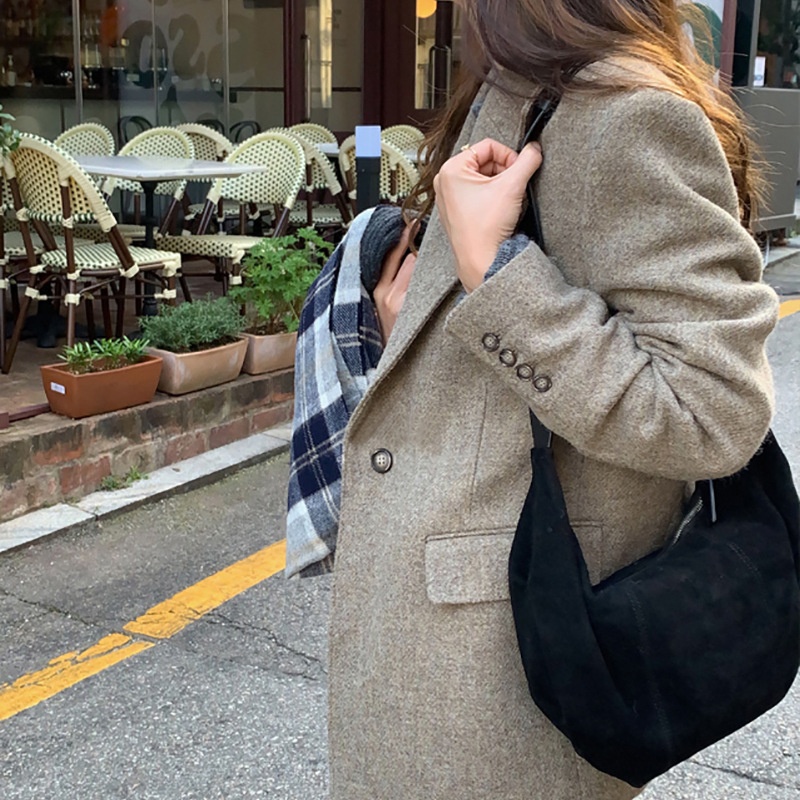 Bolso de hombro tipo hobo de ante con cierre de cremallera.