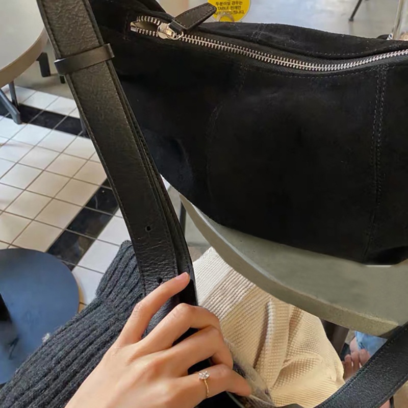Bolso de hombro tipo hobo de ante con cierre de cremallera.
