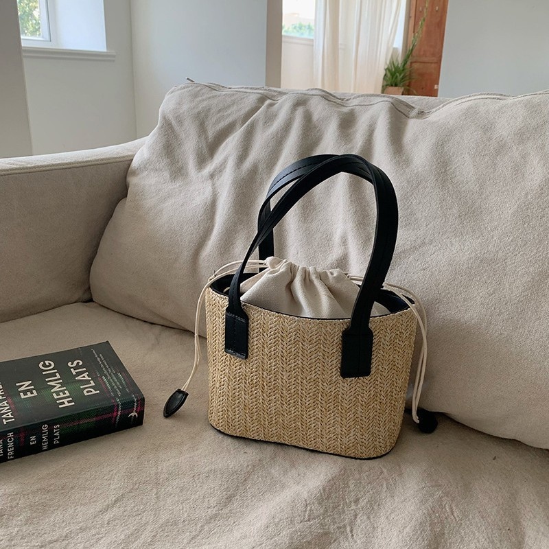 Minibolso elegante de paja tejida con forro de cordón ajustable.