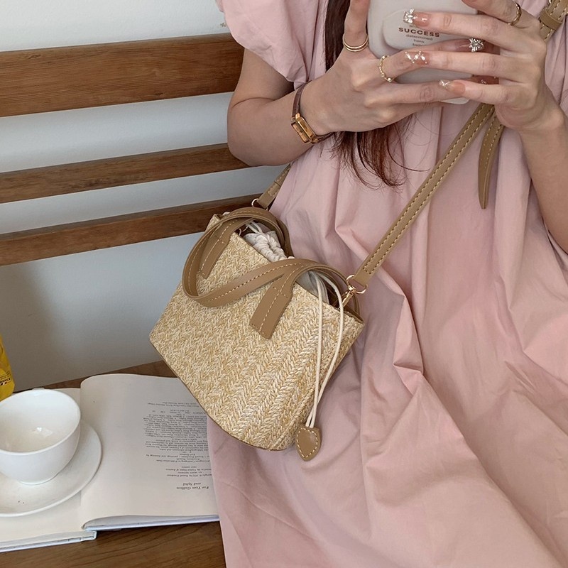 Minibolso elegante de paja tejida con forro de cordón ajustable.