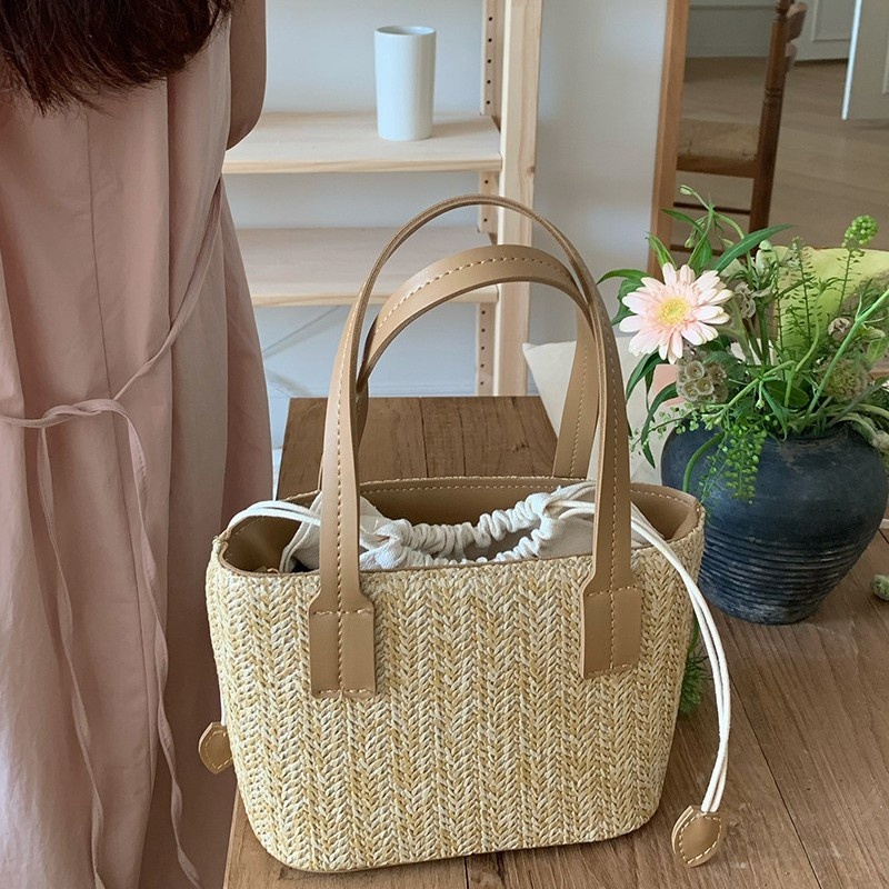 Minibolso elegante de paja tejida con forro de cordón ajustable.