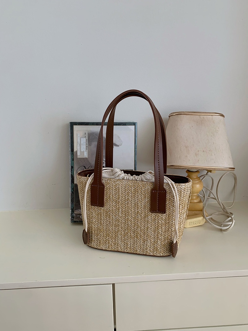 Minibolso elegante de paja tejida con forro de cordón ajustable.