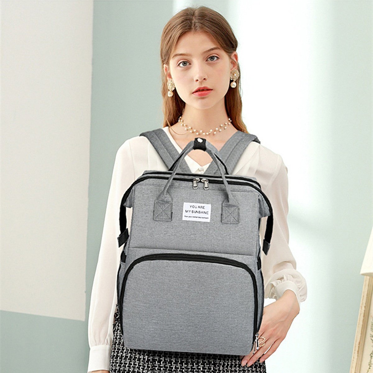 Zaino fasciatoio 2 in 1 con culla portatile, fasciatoio, tasche termiche e porta di ricarica USB.